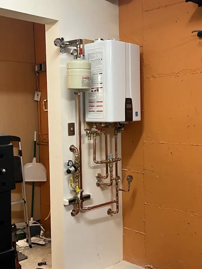 Plumbing technician inspecting water heater connections in Marshfield